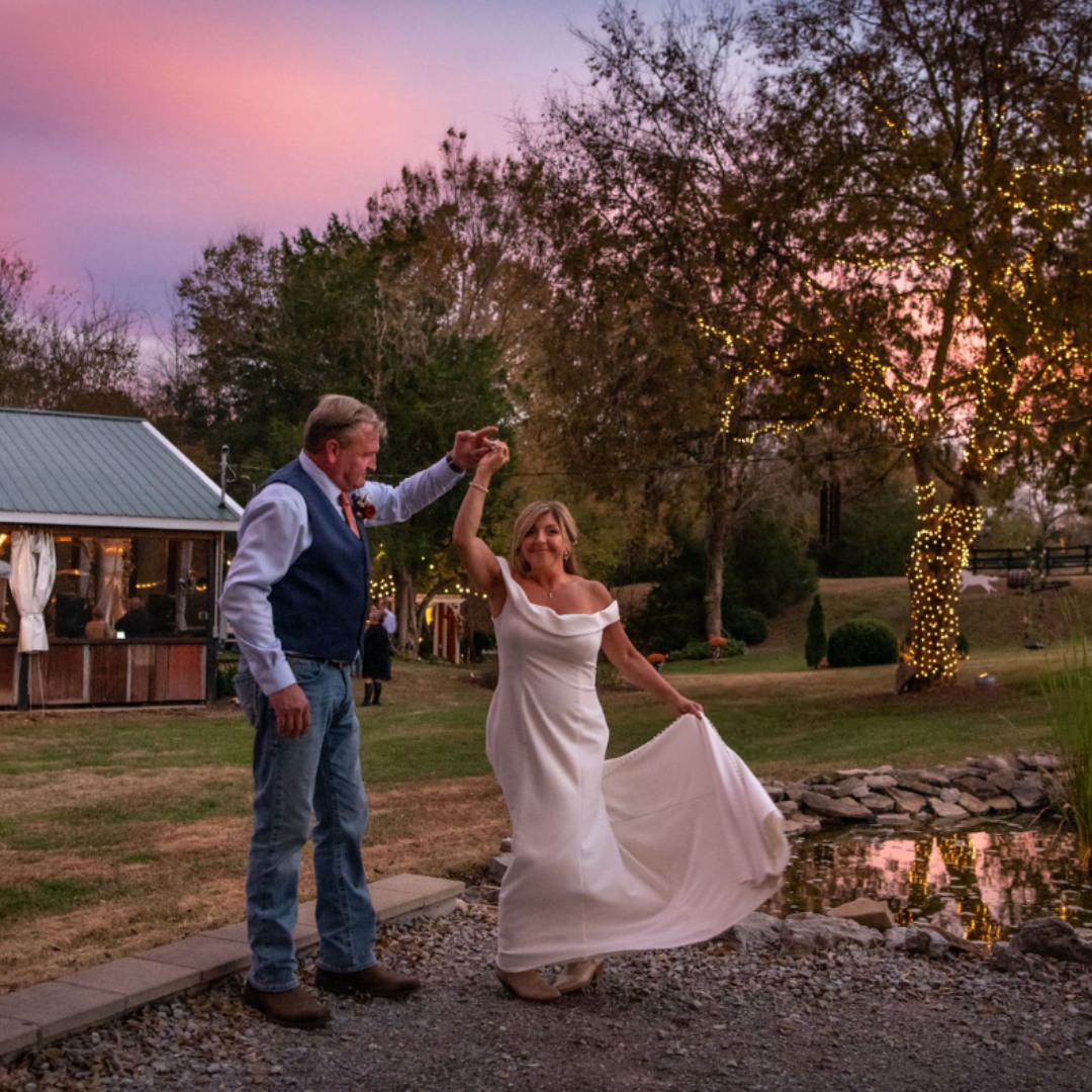 groom twirling bride at sunset