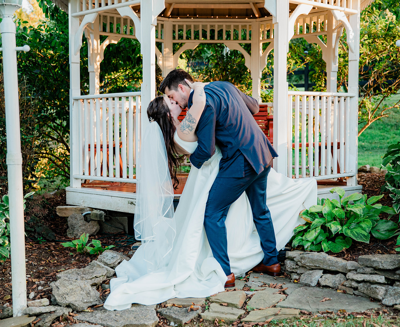 bride and groom kissing under pavilion